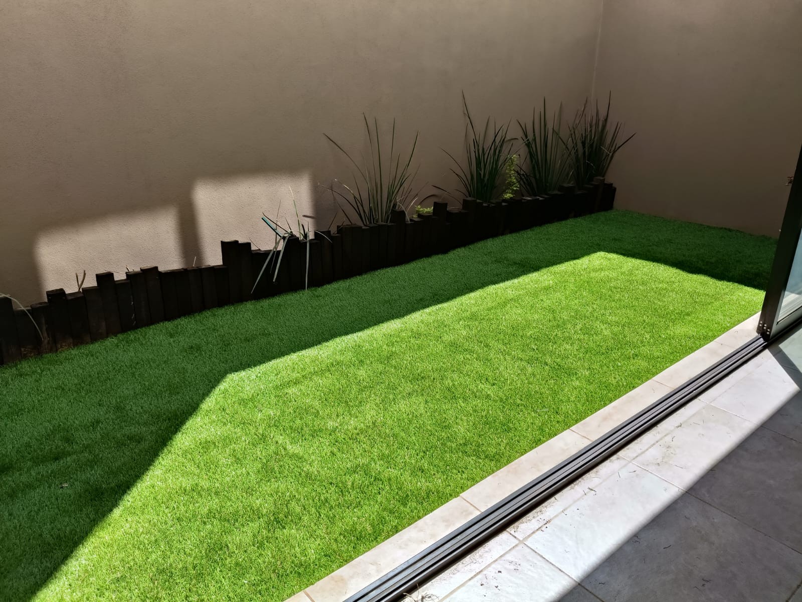 Jardín residencial con pasto sintético instalado